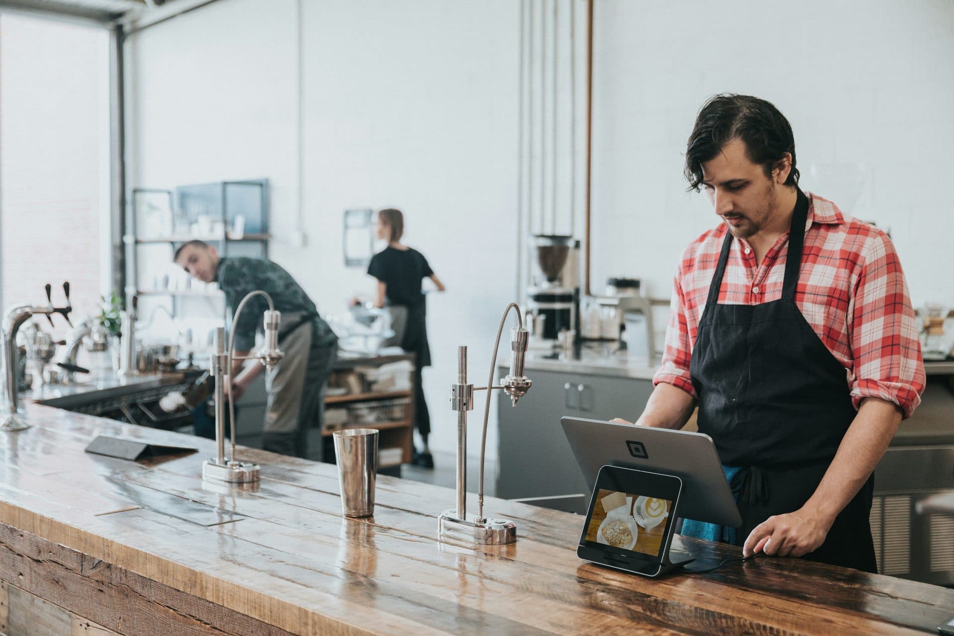 A member of staff working from a tablet on a counter